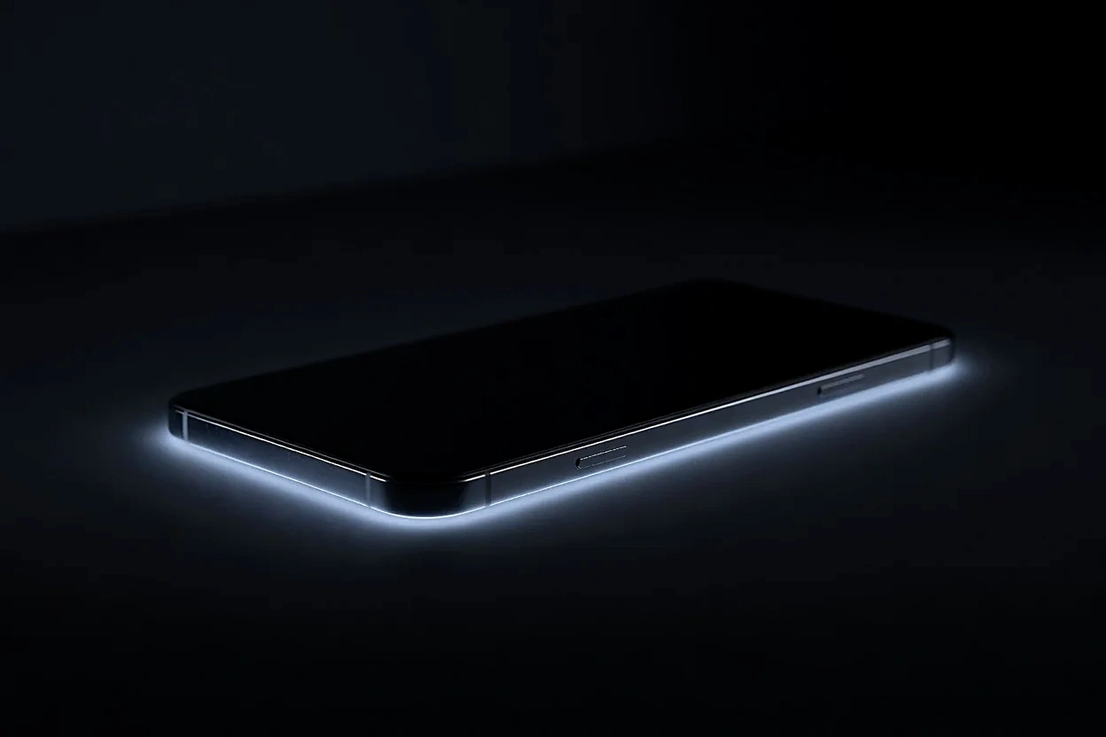 Close-up of a smartphone edge glowing faintly in a dark room